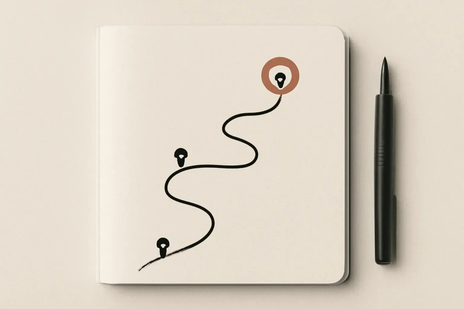A notebook, a pen and a sketched roadmap seen from above.